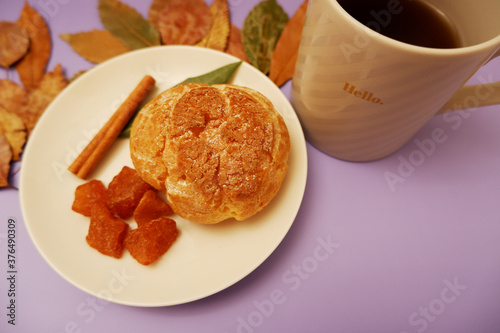 Cinnamon sweets and cup of coffee on colorful background.                                     