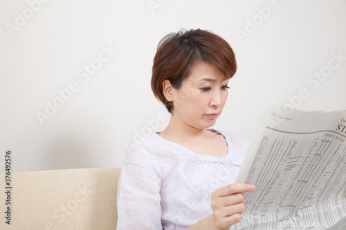 新聞を読むミドル女性