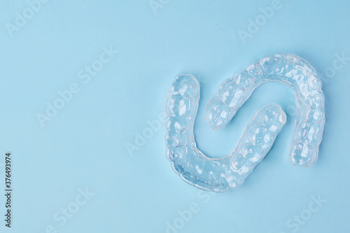 Removable teeth aligners on the blue background with copy space. Orthodontic treatment for beautiful smile.