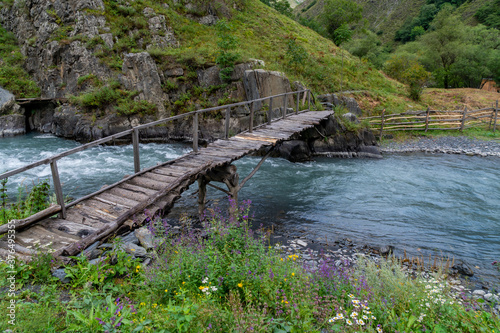 Old wooden bridge over a river Argun in Upper Khevsureti, Georgia photo