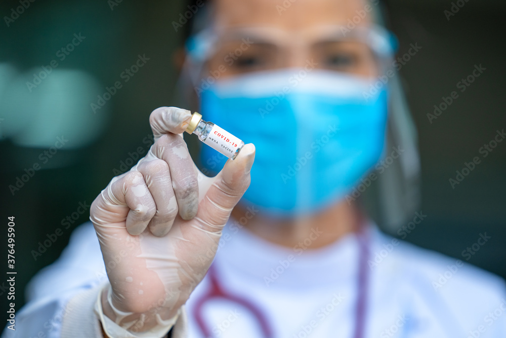 Female doctor wearing gloves and face mask protective with corona vaccine bottle on hand and bottle have Female doctor wearing gloves and face mask protective with corona vaccine bottle on hand and bottle have