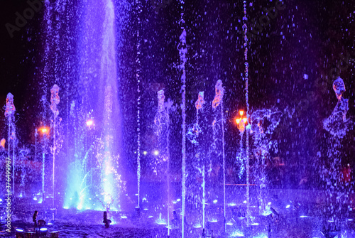 Colorful musical fountain at night. Fountain of frozen splashes. Chelyabinsk, Russia, 05 September 2020. blurred image, colored bokeh.