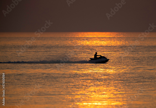 A person driving water scooter during sunset at Busiateen coast