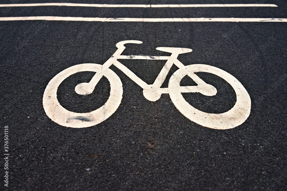Urban bike path icon on dark asphalt.