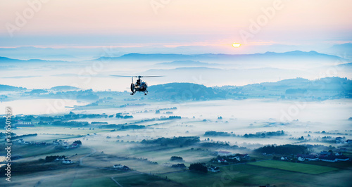 Helicopter flying in over landscape at sunrise in western Norway