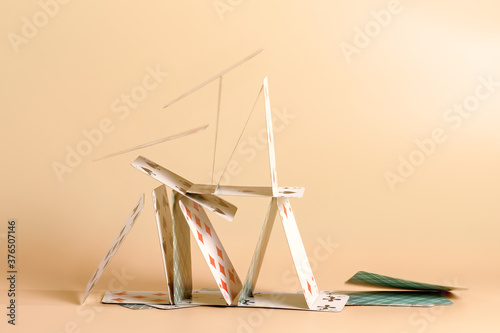 Falling house of cards on beige