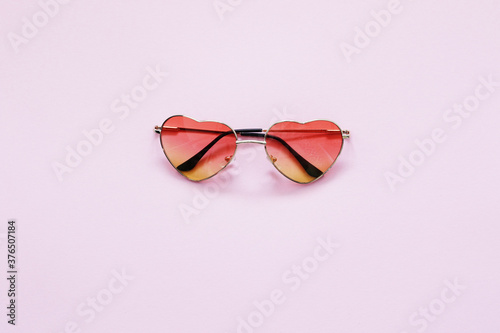 red heart shape sunglasses on pink background