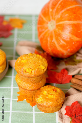autumn baking pumpkin cupcakes with fresh seasonal pumpkin and cinnamon spices. from the top view . autumn composition with pumpkins and yellow leaves