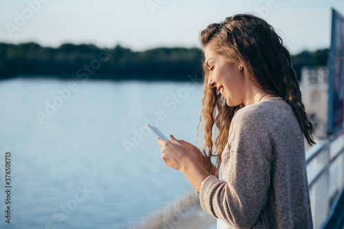 Smiling young woman looking in mobile phone