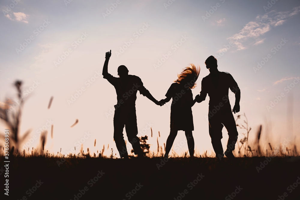 three friends running across the field at night