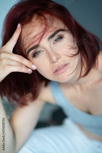 Beautiful young stylish ginger woman with freckles. Fashion portrait of charming girl wearing casual clothes posing at home. Passion