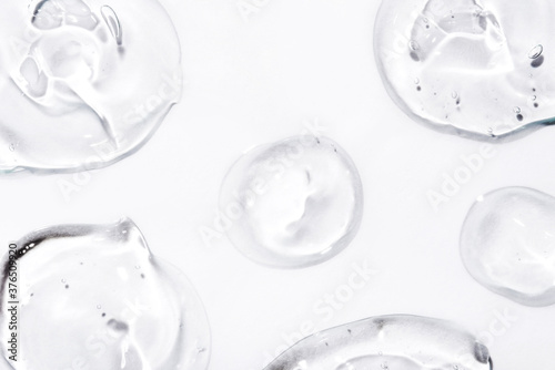 Transparent hyaluronic acid gel drops on a white background.