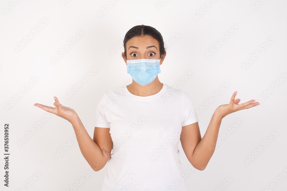 Young arab woman wearing medical mask standing over isolated white background celebrating crazy and amazed for success with arms raised and open eyes screaming excited. Winner concept Young arab woman wearing medical mask standing over isolated white background celebrating crazy and amazed for success with arms raised and open eyes screaming excited. Winner concept