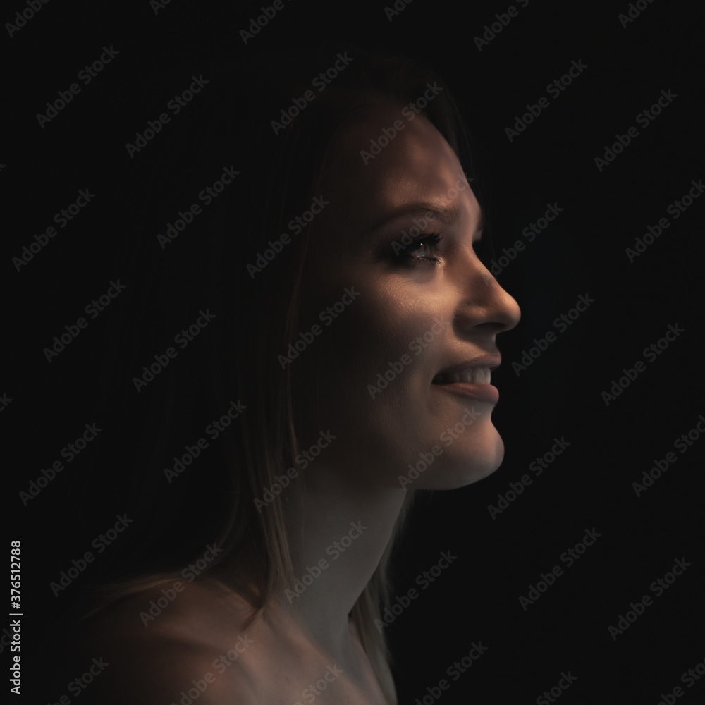 Beautiful mid adult woman with interesting pattern of light and shadow on her face. Beauty female portrait in profile. Beautiful mid adult woman with interesting pattern of light and shadow on her face. Beauty female portrait in profile.