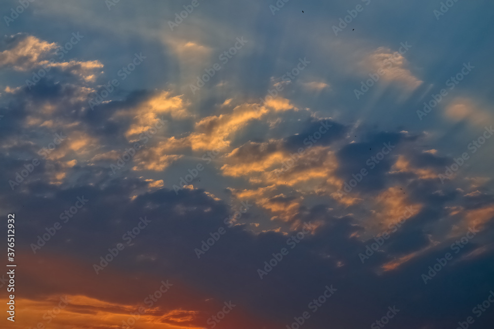 The sky at sunset. Cumulus clouds lit by the rays of the setting sun. The sky at sunset. Cumulus clouds lit by the rays of the setting sun.