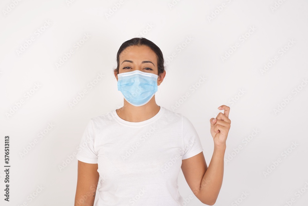 Young arab woman wearing medical mask standing over isolated white background pointing up with fingers number nine in Chinese sign language Jiu Young arab woman wearing medical mask standing over isolated white background pointing up with fingers number nine in Chinese sign language Jiu