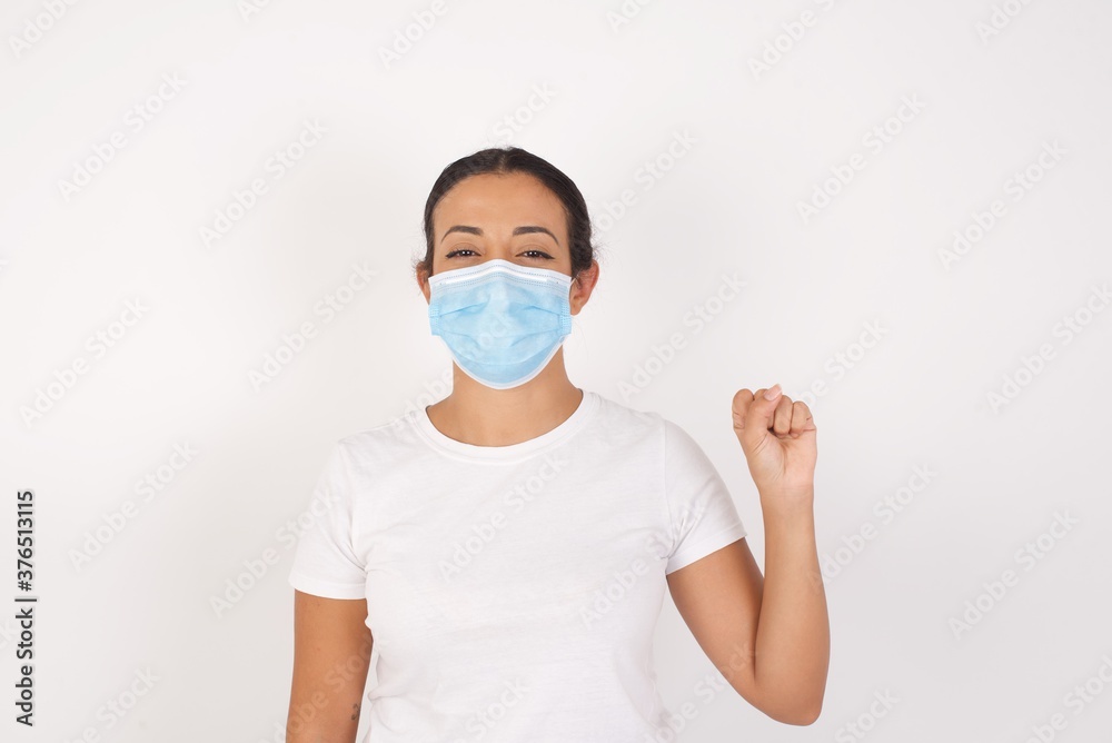 Young arab woman wearing medical mask standing over isolated white background pointing up with fingers number ten in Chinese sign language Shi Young arab woman wearing medical mask standing over isolated white background pointing up with fingers number ten in Chinese sign language Shi