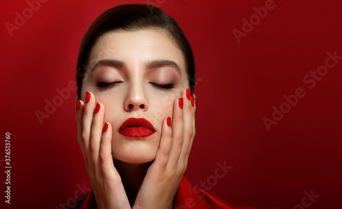 Portrait of beautiful young woman wearing red clothes with perfect young skin  red matt lips and nails.