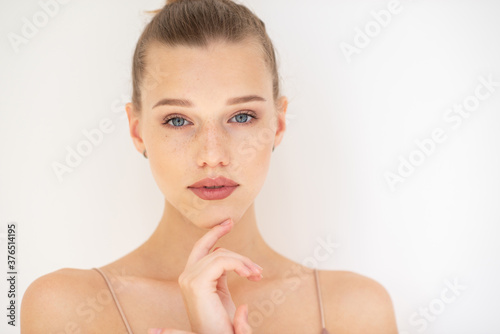 Pretty girl. Portrait of beautiful young woman with clean skin, blue eyes, fair hair and freckles, youth concept, beauty treatment. Cheerful teenager, beauty female face happy smiling over white.