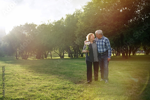 Happy senior couple walking in the park at sunset     © D'Action Images