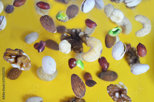 Nuts in the air on a yellow background, flying nuts. Healthy Brain Food, Diet, Protein, Almonds, walnuts and hazelnuts peanut, cashews, pistachios