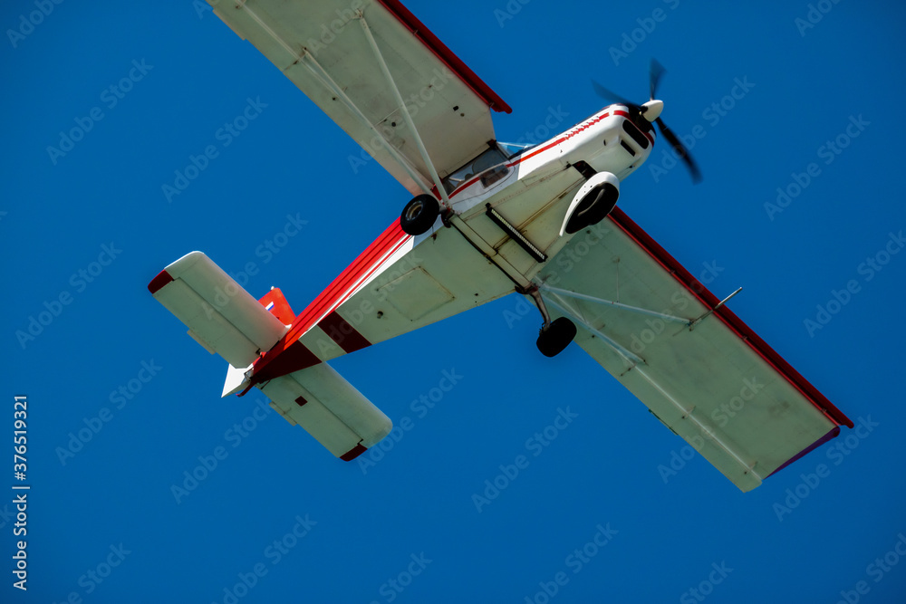 Obraz premium Light-engine two-seat aircraft in the air close-up. Bottom view.