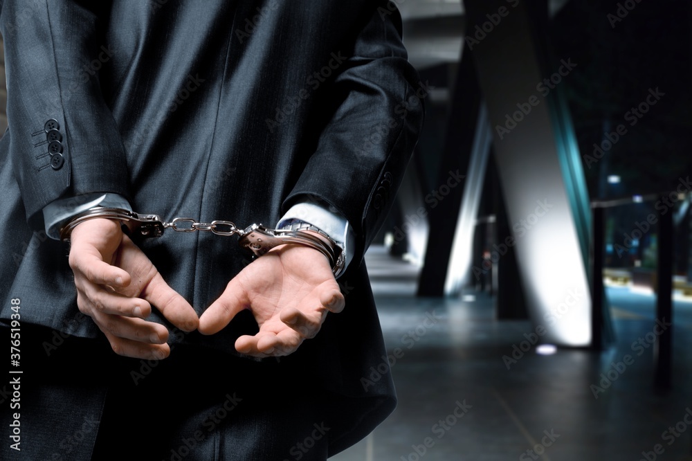 Fototapeta premium Criminal man with his hands in handcuffs