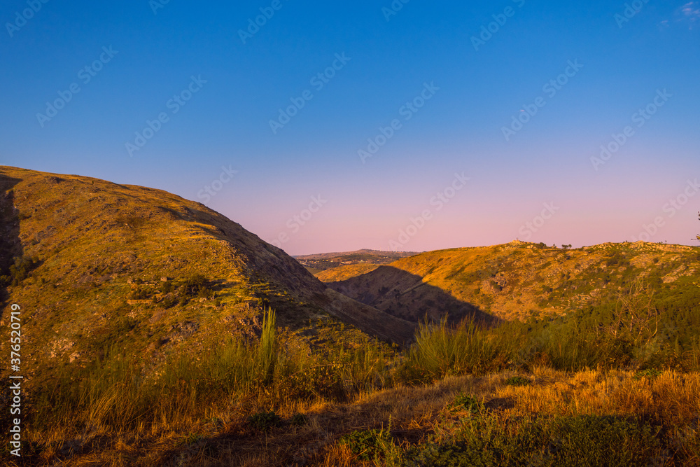 Fototapeta premium View over the mountain with the horizon in blue and orange tones.