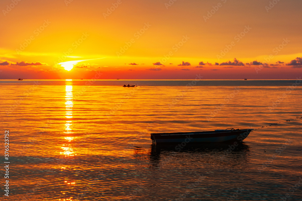 Sun sinking below the horizon line at sunset