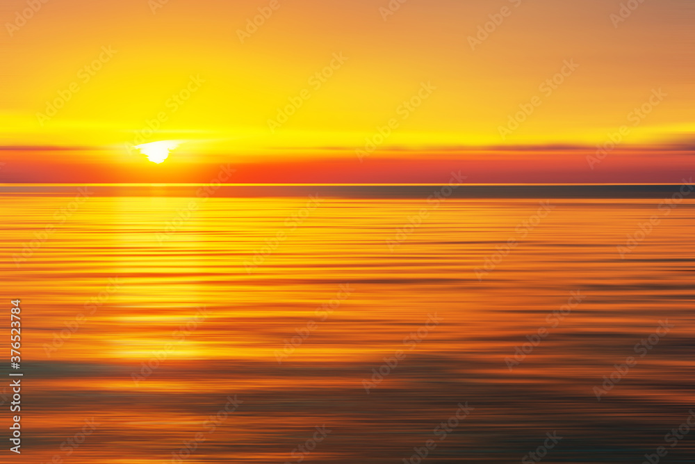 Sun sinking below the horizon line at sunset