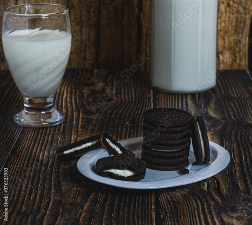 delicious milk chocolate cookies on a wooden table with a glass