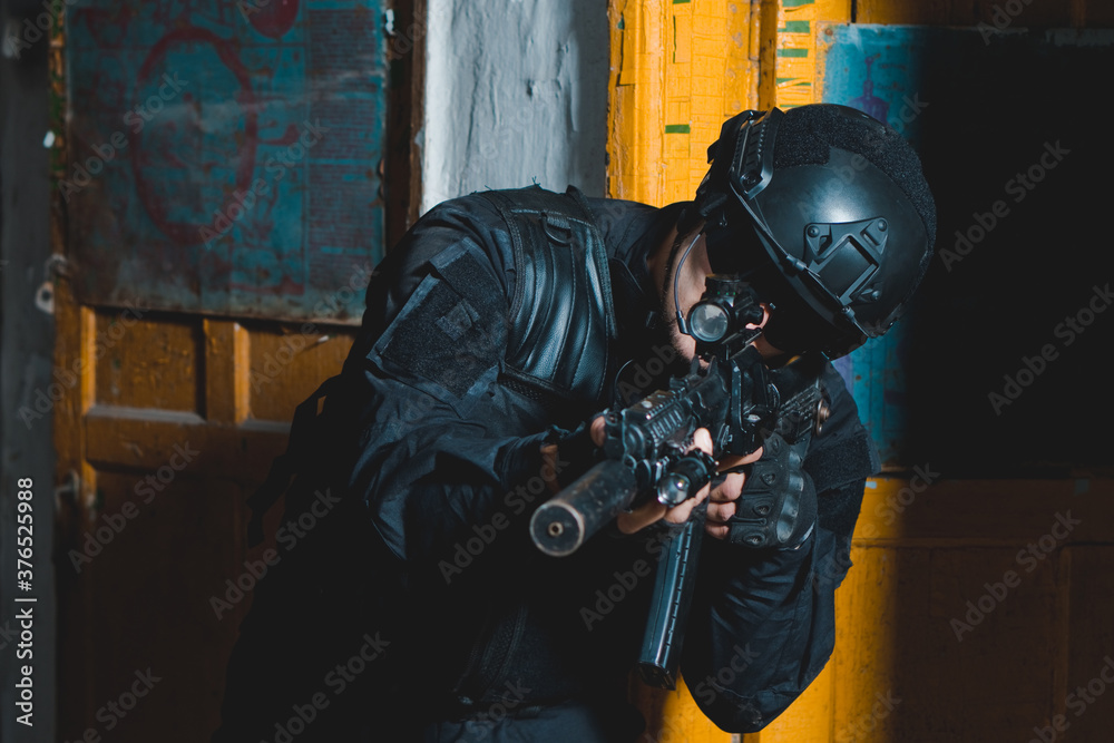 Special forces soldier in black uniform aiming with a rifle Stock Photo ...