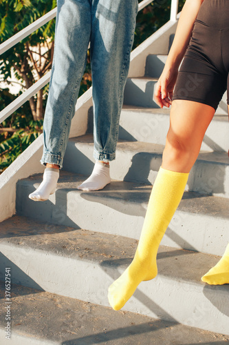 two girls go down the stairs in colored socks without shoes. socks advertising concept