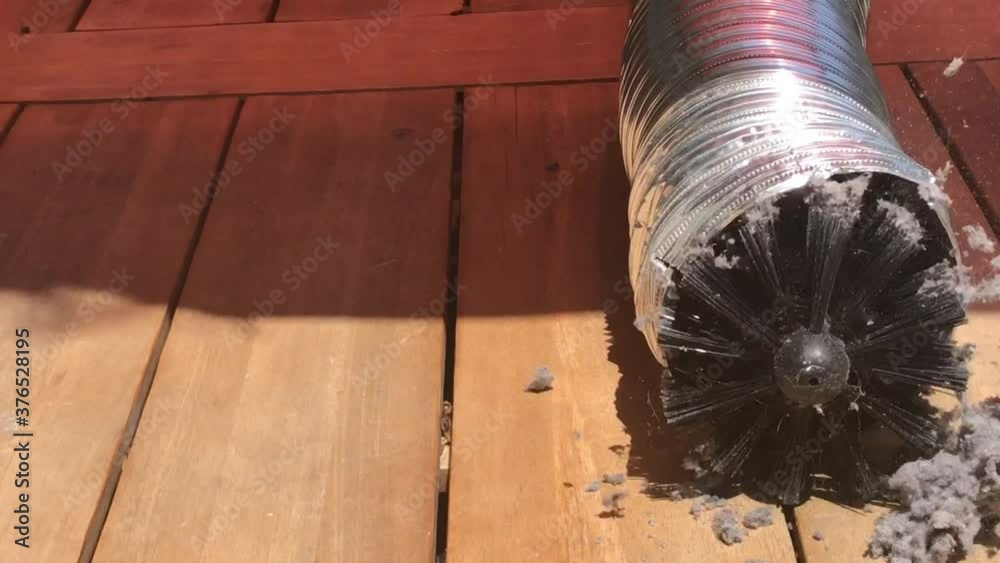 Rotating brush on drill cleaning lint buildup in dryer vent pipe