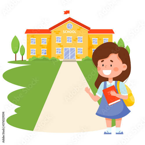 Schoolgirl with a backpack and a book near the school building. Back to school concept.