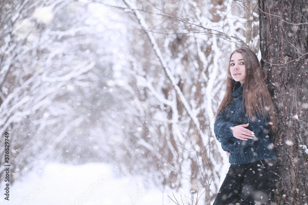 Girl in a winter park in snowfall Girl in a winter park in snowfall