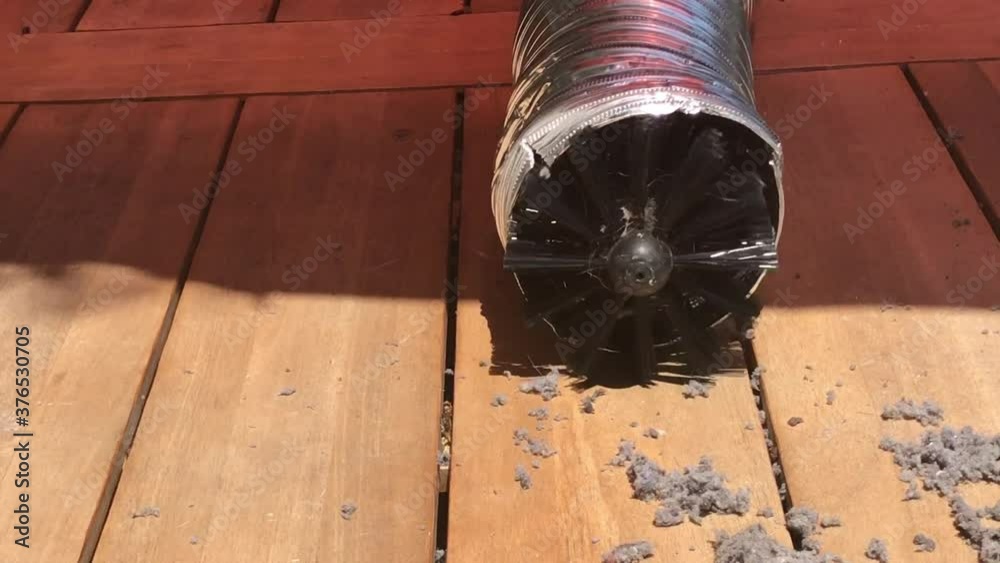 Rotating brush on drill cleaning lint buildup in dryer vent pipe