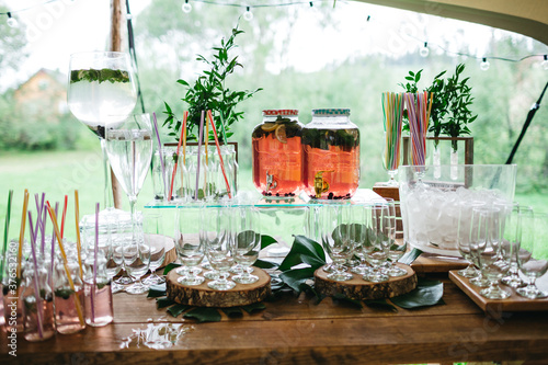Front view of drink bar on formal occasion. Empty glasses on wooden table. Preparing for big gala night, prom, birthday celebration with alcohol free cocktails. Concept of sober party for adults.