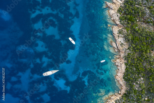 View from above, stunning aerial view of some boats floating on a turquoise, clear water. Sardinia, Italy. Sardinia is the second-largest island in the Mediterranean Sea.