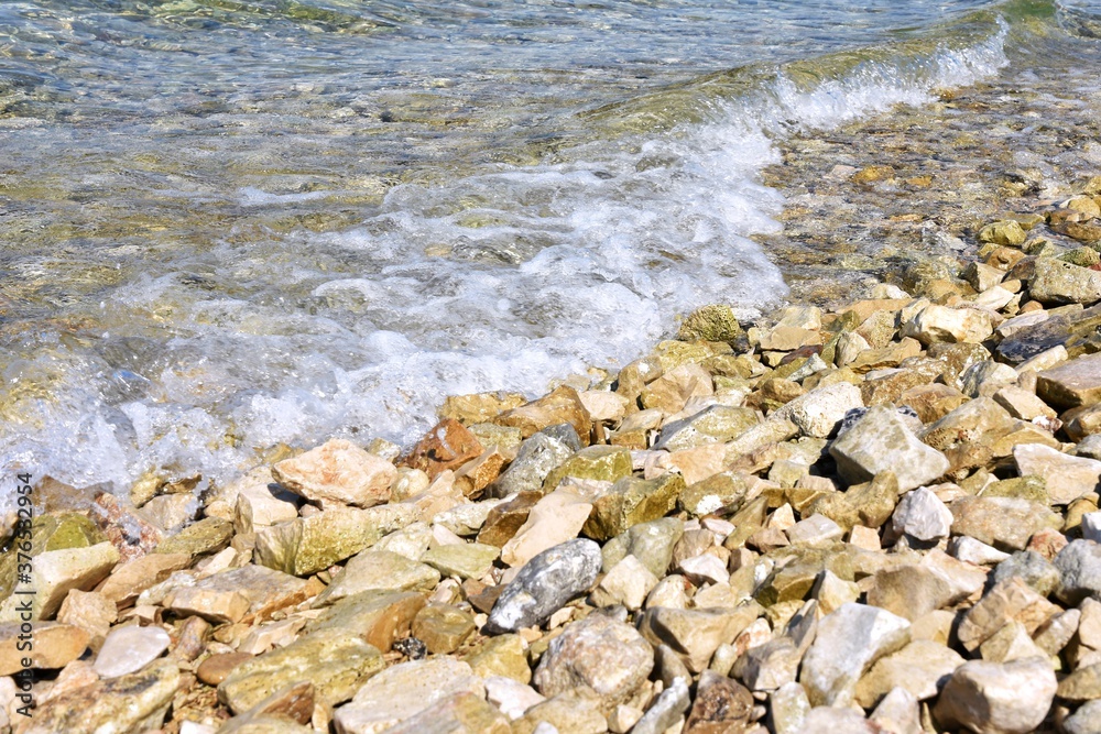 rocky stone beach in Croatia. Adriatic sea. Close-up of water with pebbles. Clean clear sea water and rocky coast
