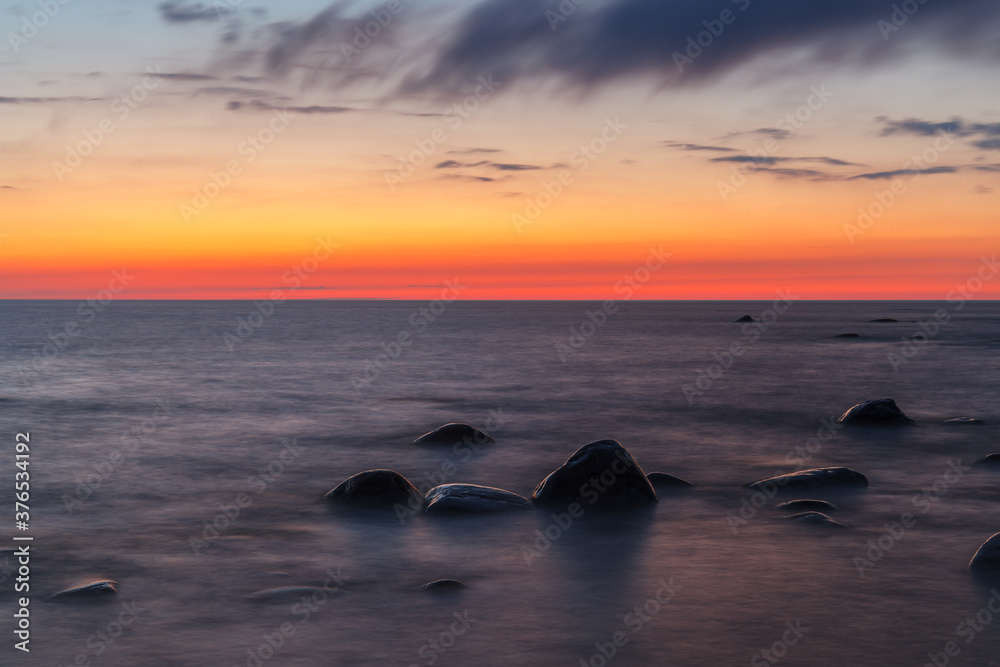Naklejka premium Rocky shore and peninsula of Baltic sea at sunset. Nordic minimalistic wilderness.