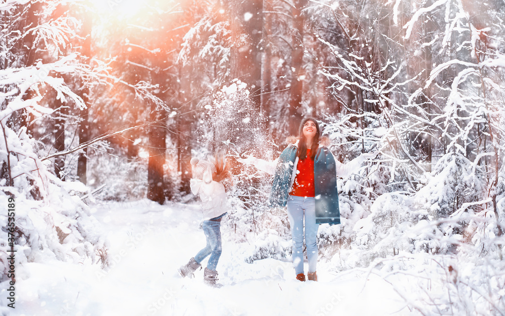 Young family for a walk. Mom and daughter are walking in a winter park. Young family for a walk. Mom and daughter are walking in a winter park.