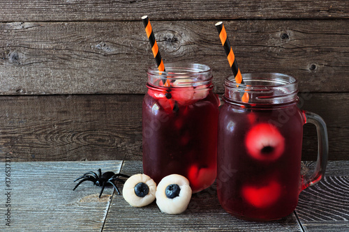 Creepy Halloween eyeball fruit punch in mason jars against an old wood background