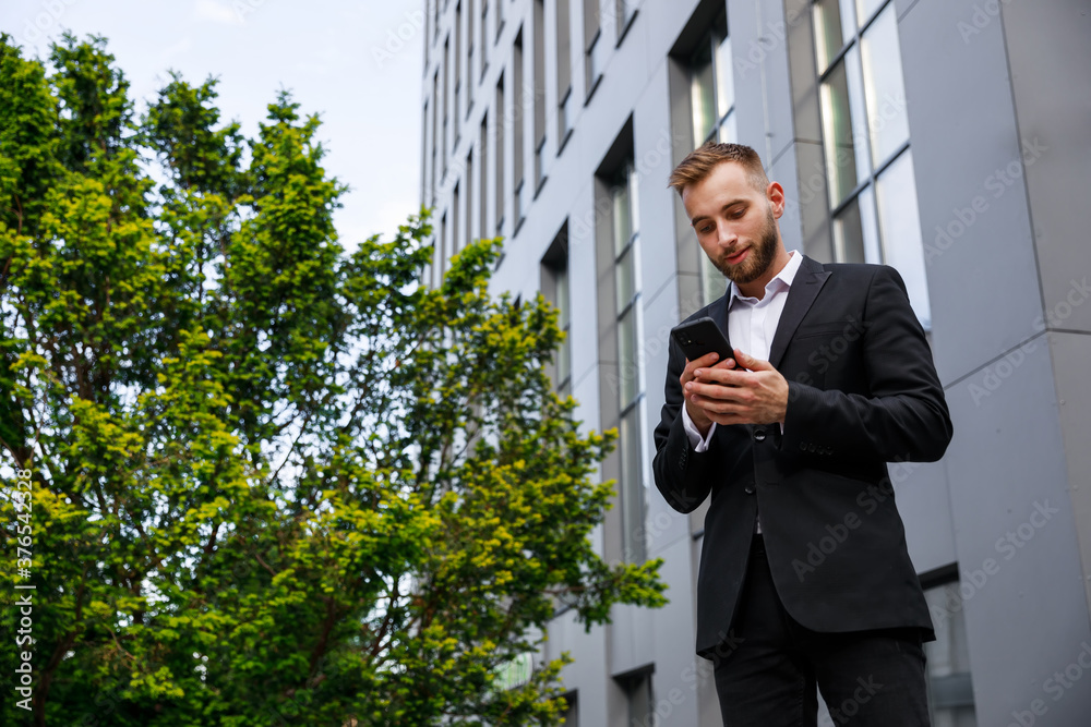 Cheerful businessman in formal clothes browses the network via s Cheerful businessman in formal clothes browses the network via s