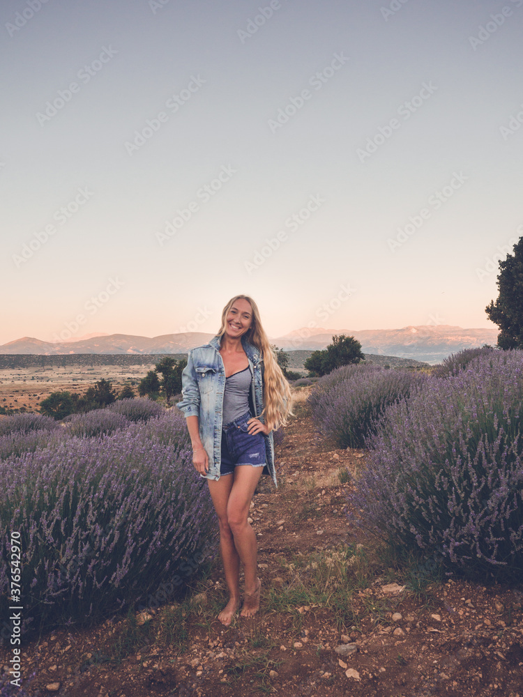 Fototapeta premium Blonde woman in denim jacket in the field