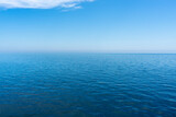 Calm. Nice weather, sunny day, calm sea or ocean. There are few clouds and can be seen very far.