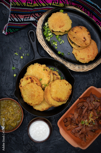 Vegan Mexican gorditas along with  fried seitan pieces , chile verde in traditional Mexican bowls
