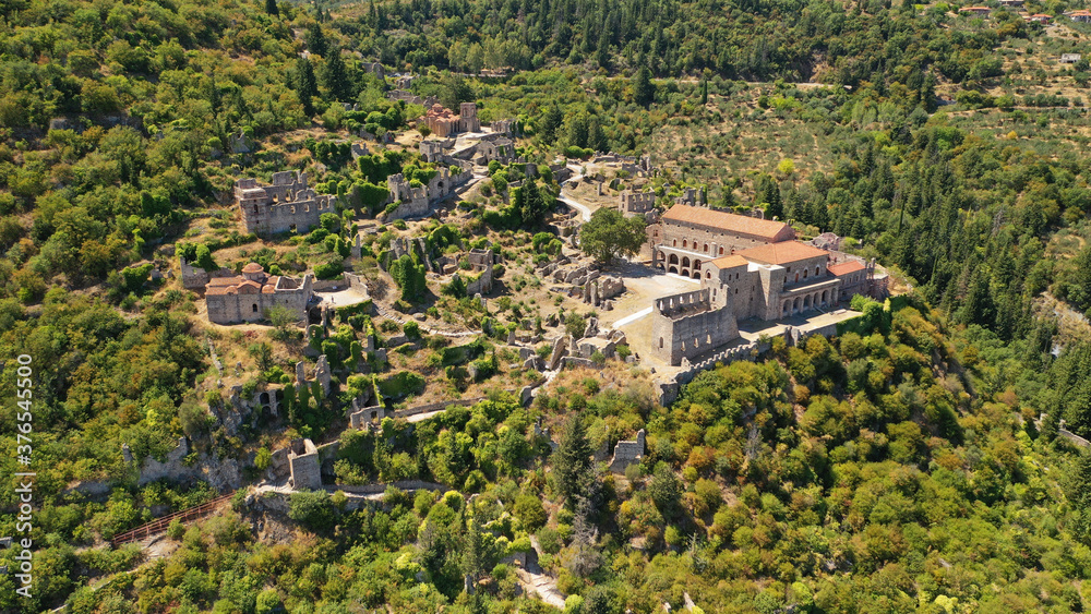 Aerial drone photo of medieval byzantine old city of Mystras featuring Monastery of Pantanassa, Temple of Agia Sofia and uphill castle of Mystras, Sparta, Peloponnese, Greece