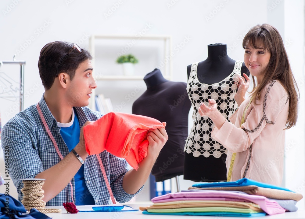 Fototapeta premium Male tailor with female student in workshop