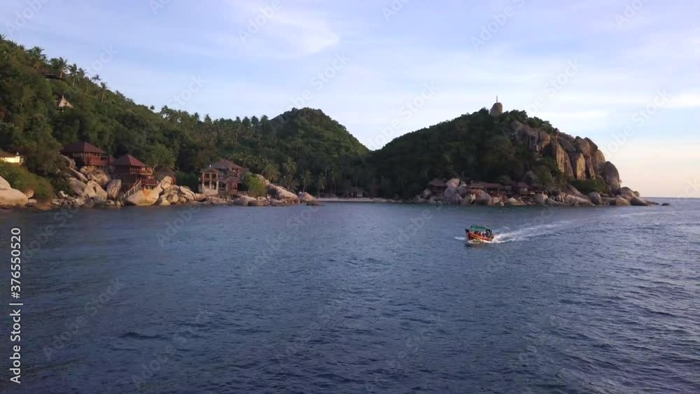 Aerial : a boat with tourists floats along the coast of Koh Tao island, Thailand Aerial : a boat with tourists floats along the coast of Koh Tao island, Thailand
